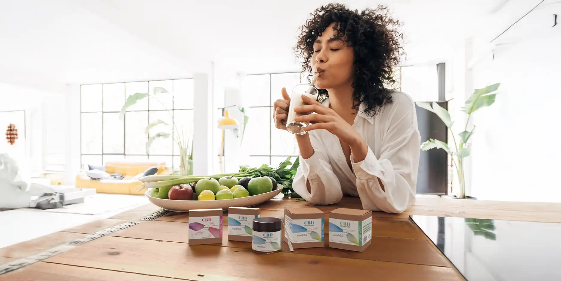 Eine Frau trinkt mit einem Strohhalm aus einem Glas.