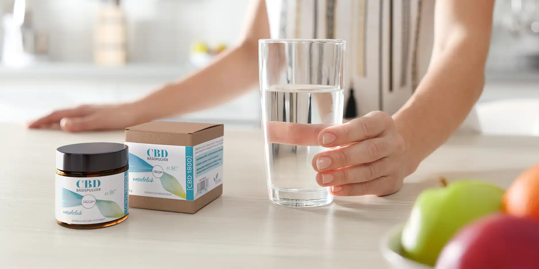 Eine Hand hält ein Glas Wasser